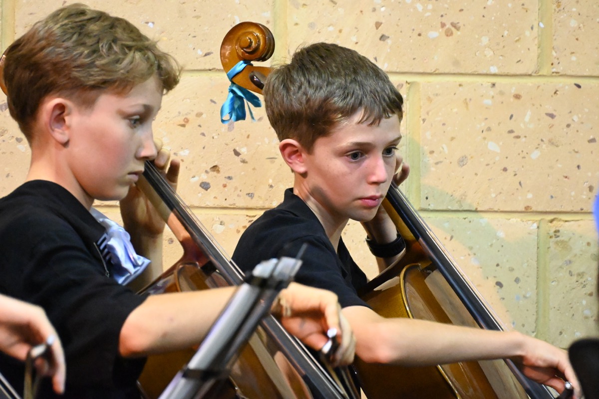 Concert moment with MNCYO musicians and conductor area visible.