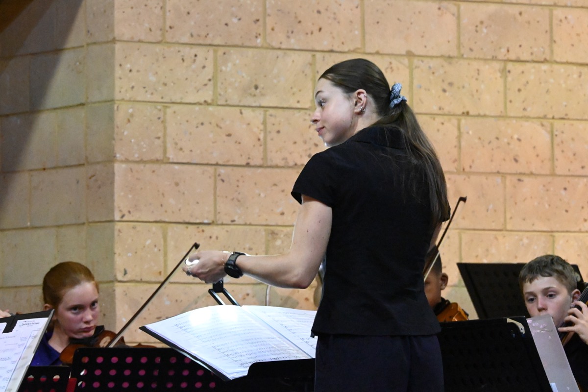 Orchestra musicians seated with instruments during the concert.